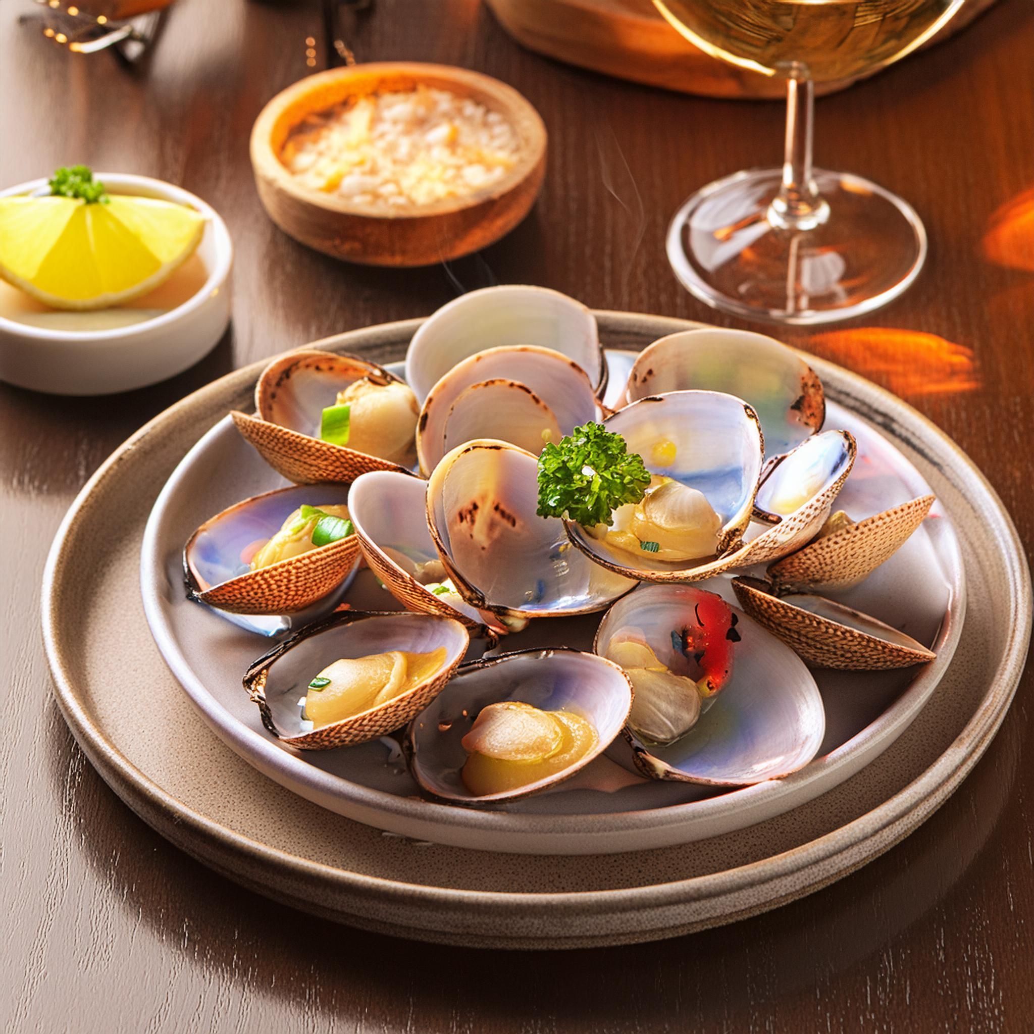 Representación PLato de almejas a la amrinera en una mesa de restaurante